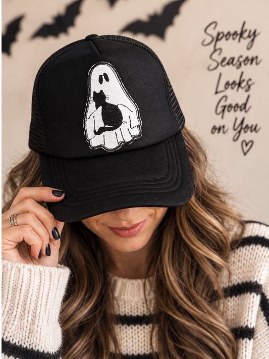 Woman wearing black ghost and black cat Halloween trucker hat