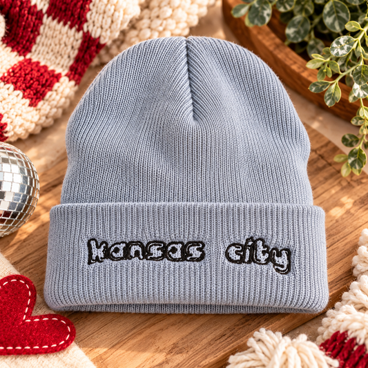 Gray embroidered Kansas City script beanie styled in a warm KC-inspired flat lay