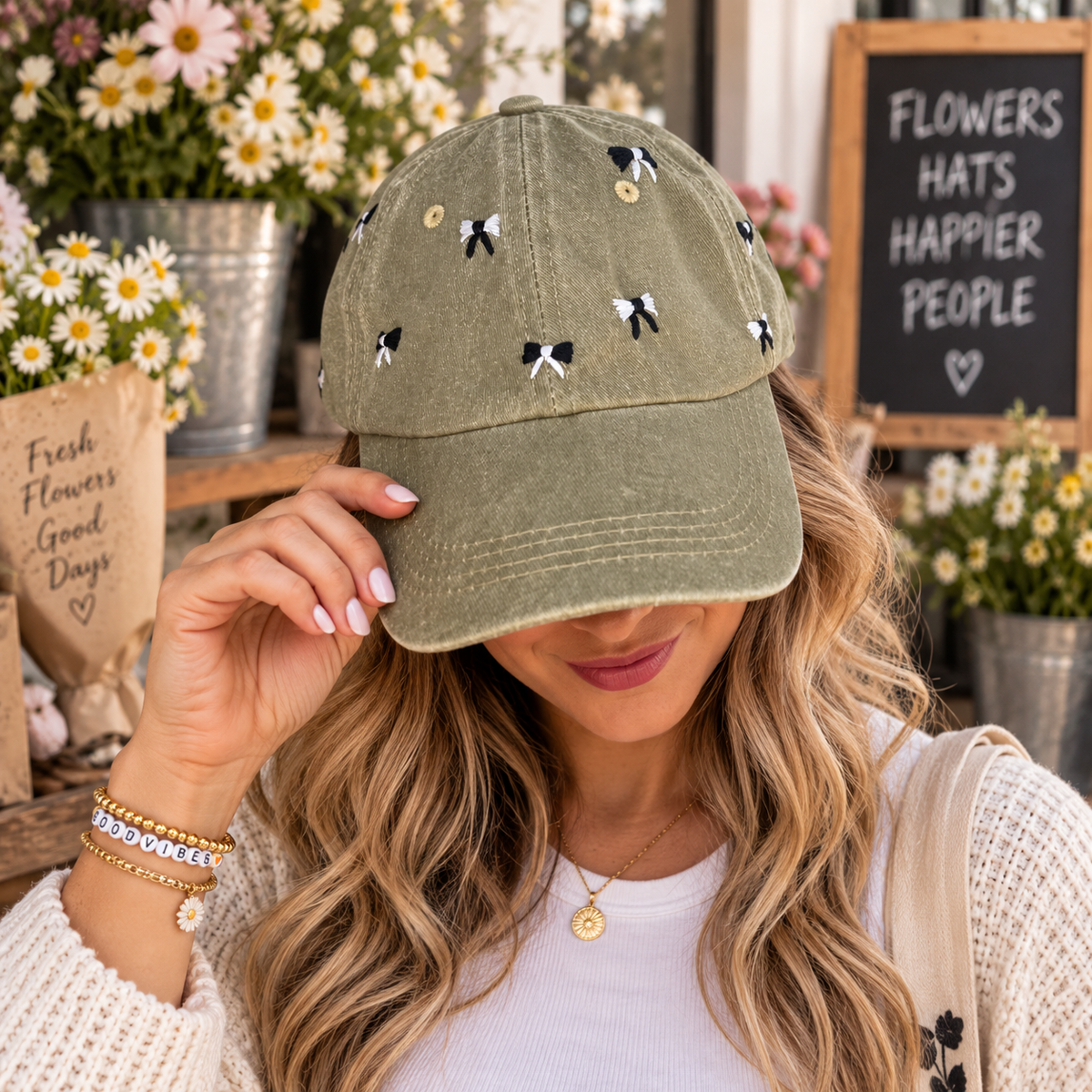 Model wearing hand-embroidered faded olive mini-bow baseball hat