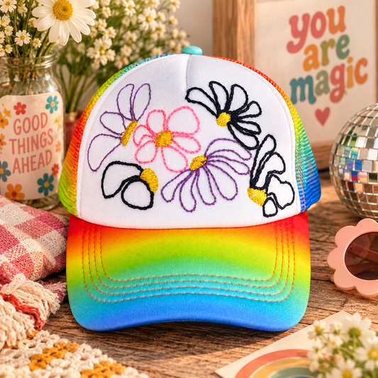 Hand-embroidered rainbow floral trucker hat styled product photo