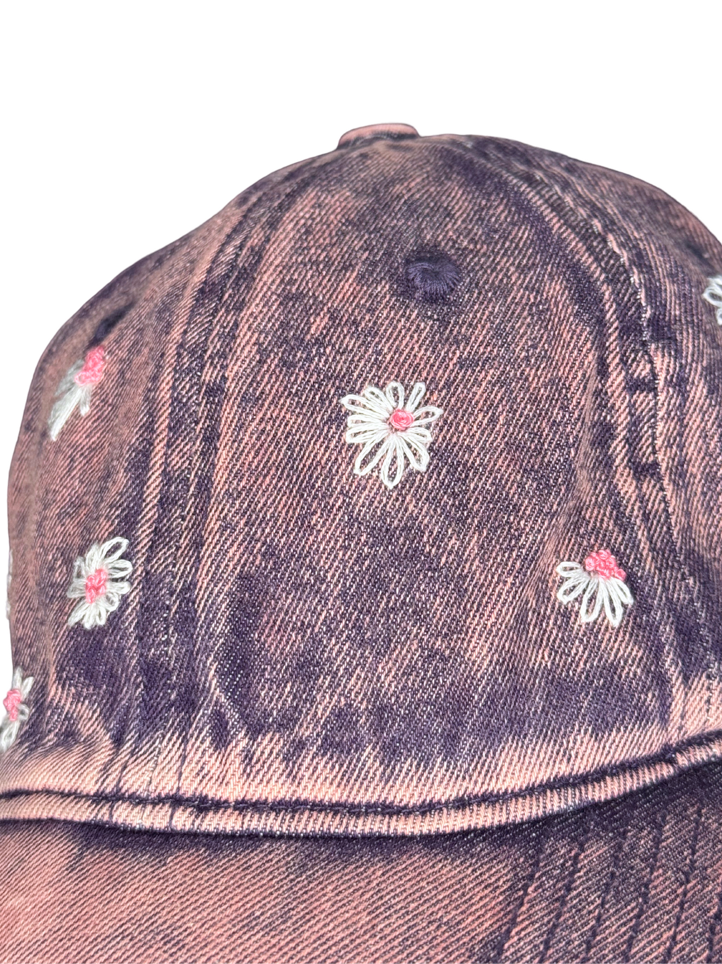 pink denim cap with floral embroidery on a white background
