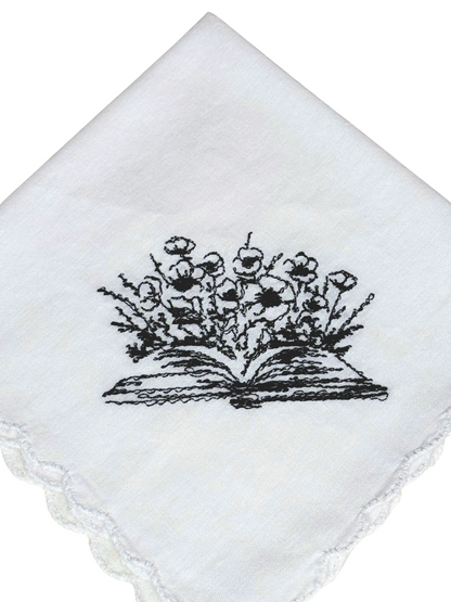 Close-up of black floral book embroidery on scalloped handkerchief


