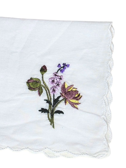 Close-up of July birth month flower embroidery on white scalloped edge handkerchief

