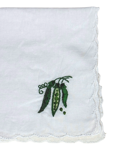 Close-up of green embroidered pea pods on white scalloped handkerchief

