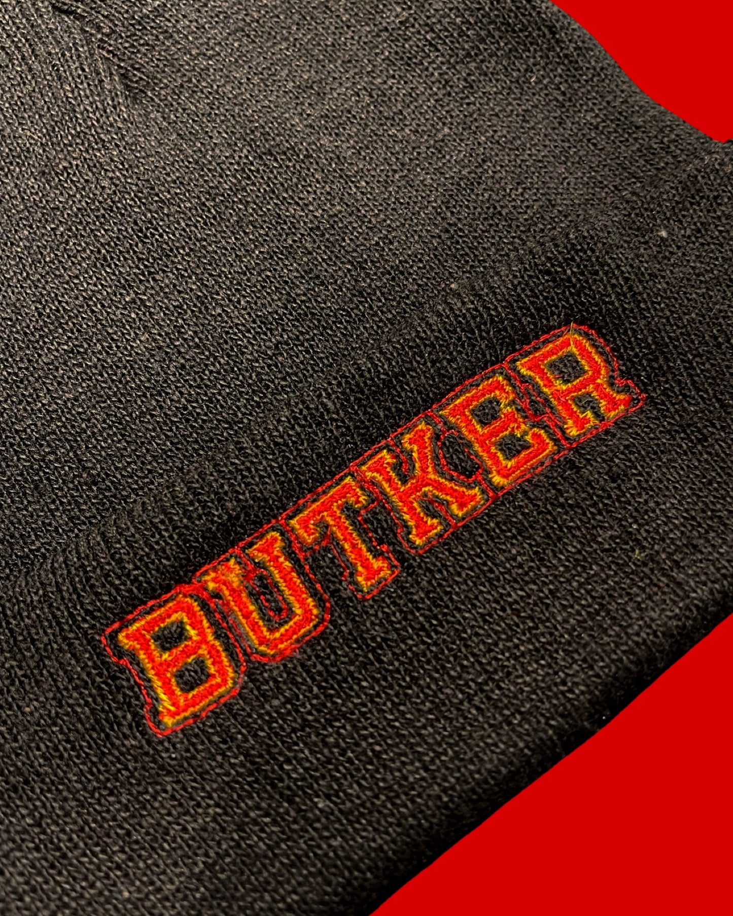 detail view of red and yellow embroidery "BUTKER"