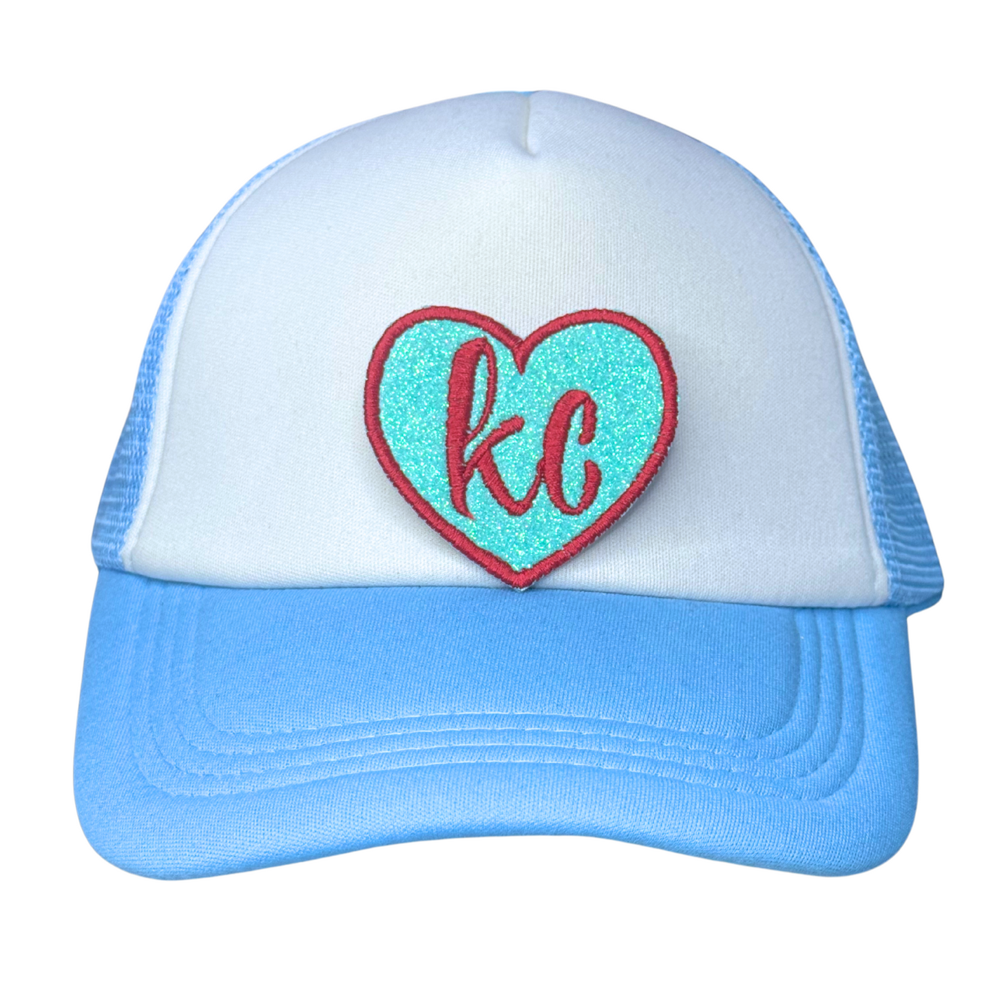 KC glitter patch displayed on white and blue trucker hat

