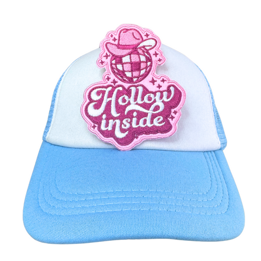 Hollow Inside embroidered patch applied to a light blue trucker hat.
