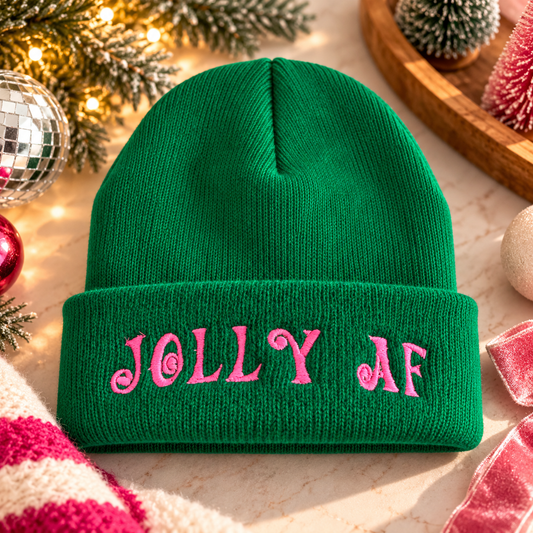 Green Jolly AF embroidered beanie with bright pink lettering in a festive holiday setting