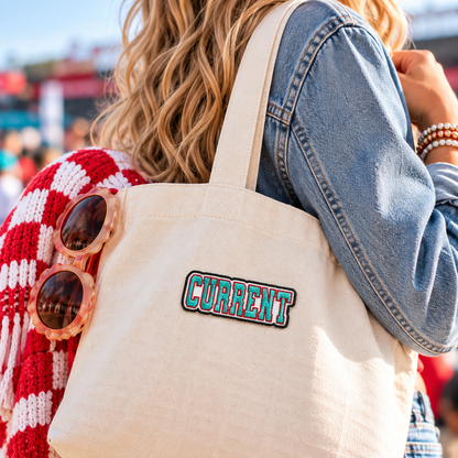 KC Current embroidered patch styled on a canvas tote