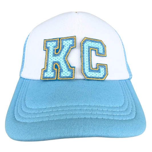 Trucker hat with KC light blue chenille patch in Royals colors with varsity-style letters

