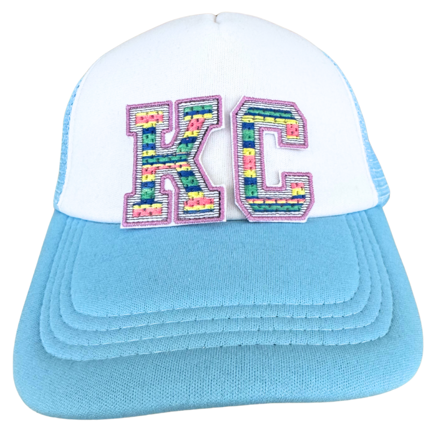 Trucker hat featuring rainbow-stitched KC patch in varsity block letters with lilac trim


