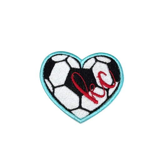 Heart-shaped soccer ball patch with “kc” embroidery in red
