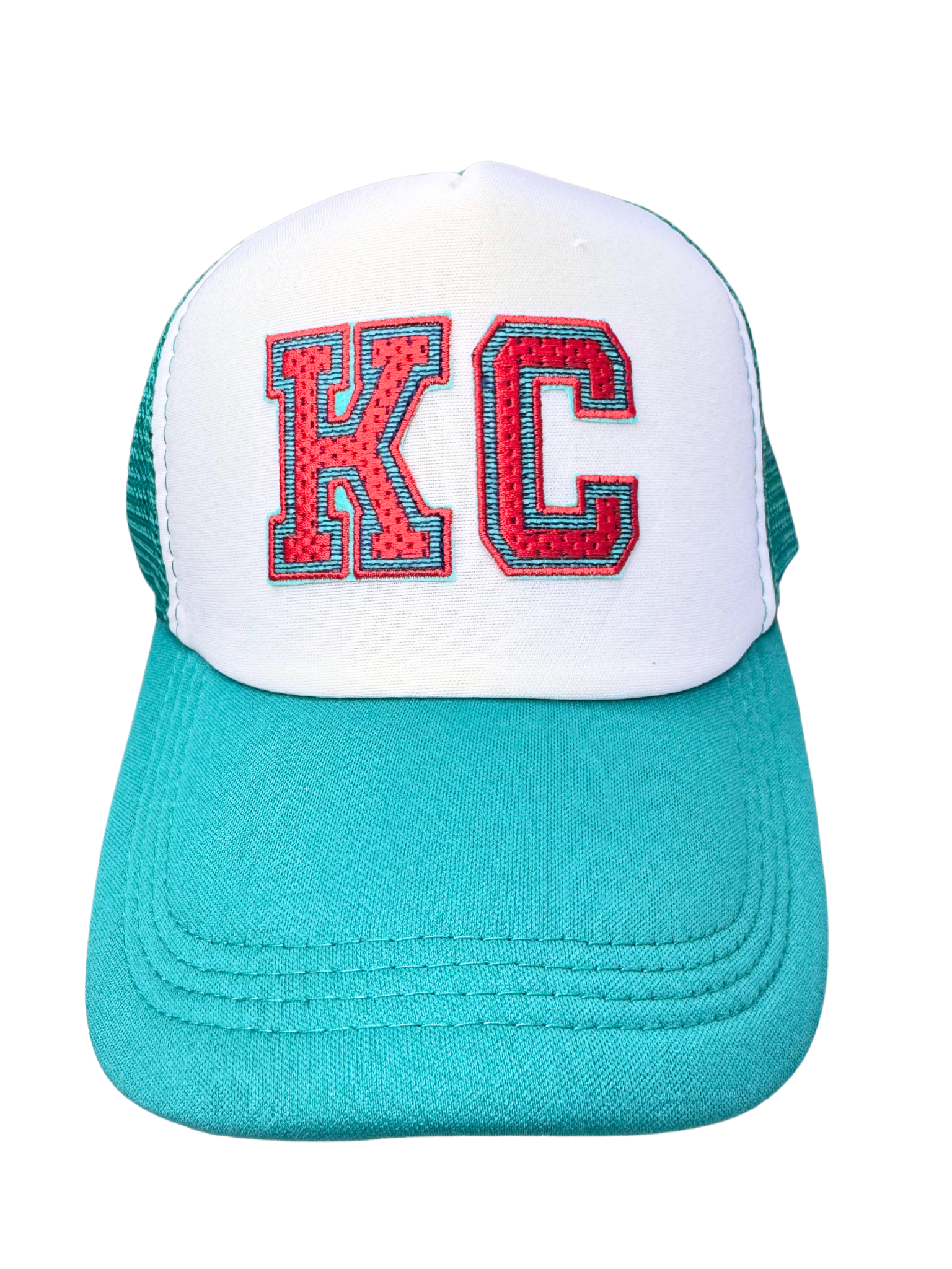 Front view of teal and white KC trucker hat with embroidered red and aqua "KC" patch
