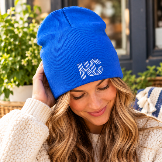 Woman wearing royal blue KC embroidered beanie with white logo, without a folded cuff