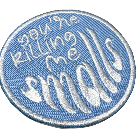 Close-up angled detail showing embroidery texture and bold text

