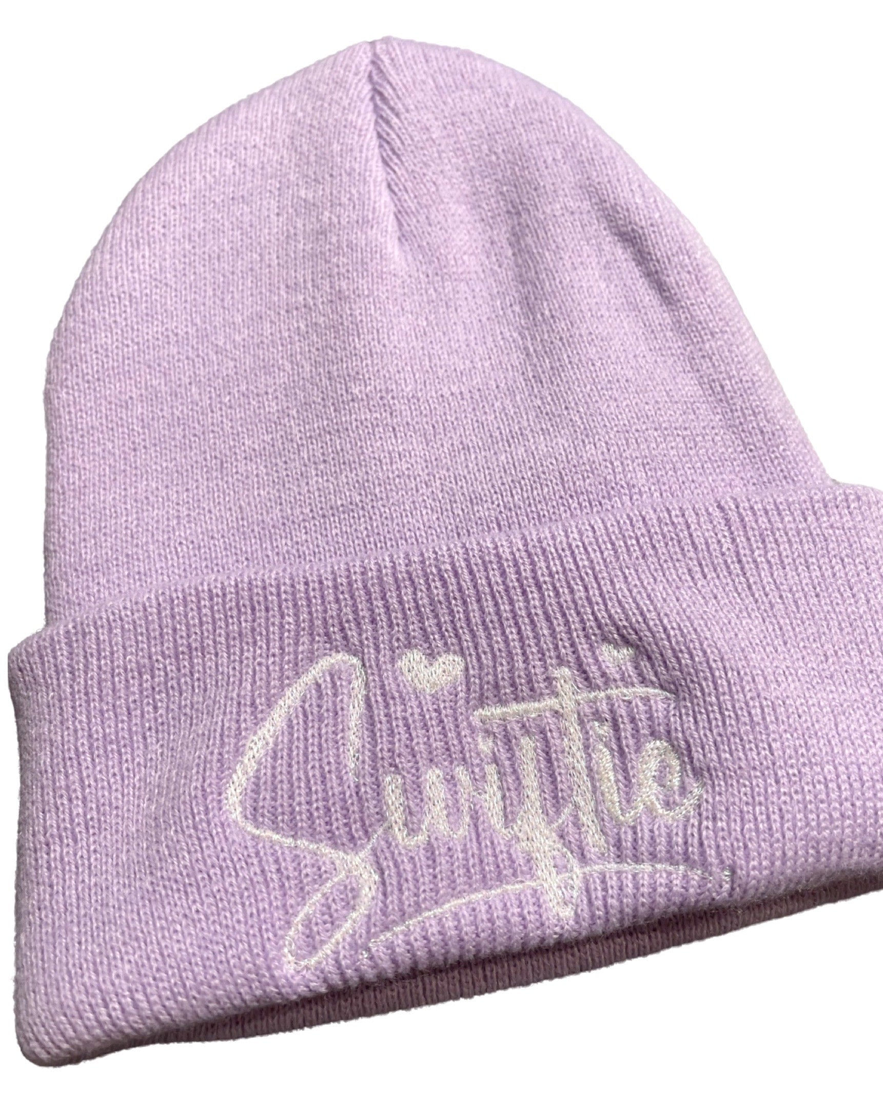 Lavender (light purple) knit beanie embroidered with the word "swiftie" in cursive with hearts for the dots on the I's. The embroidery is done with a white pearlized thread.