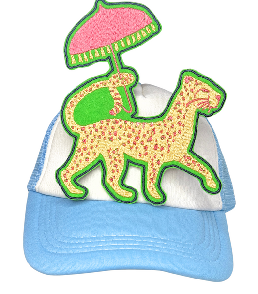 Leopard vacation patch with parasol ironed onto blue and white trucker hat

