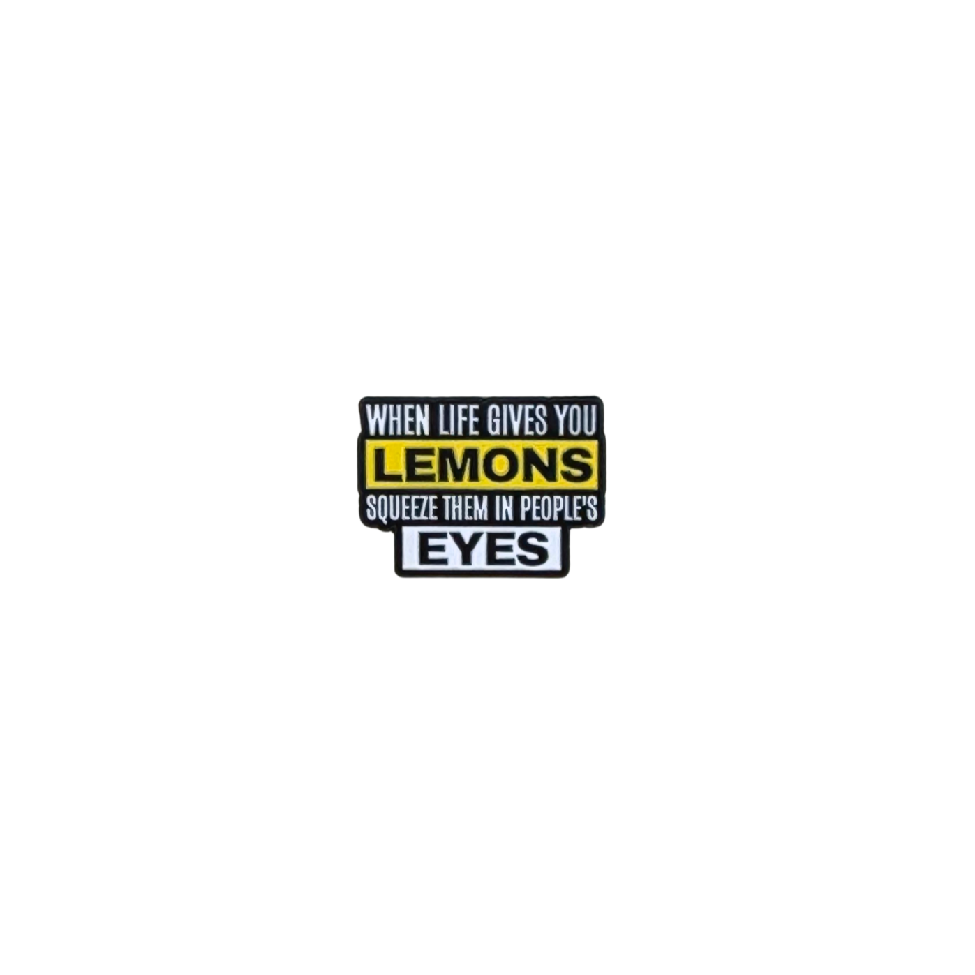 Enamel pin that says “When life gives you lemons, squeeze them in people’s eyes” on white background

