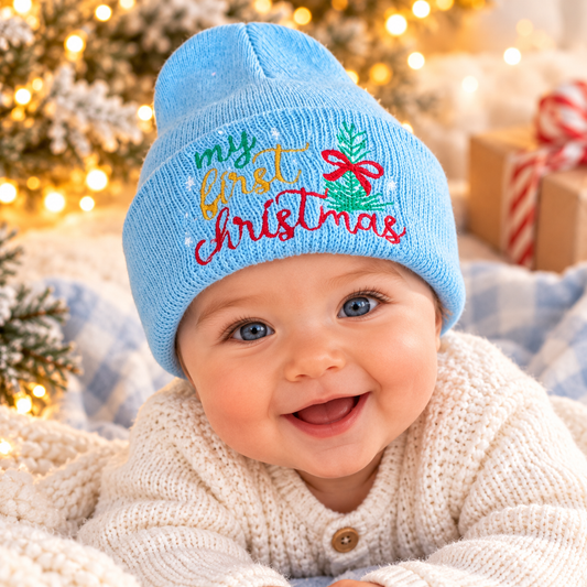 Baby wearing light blue My First Christmas embroidered beanie in a cozy holiday setting