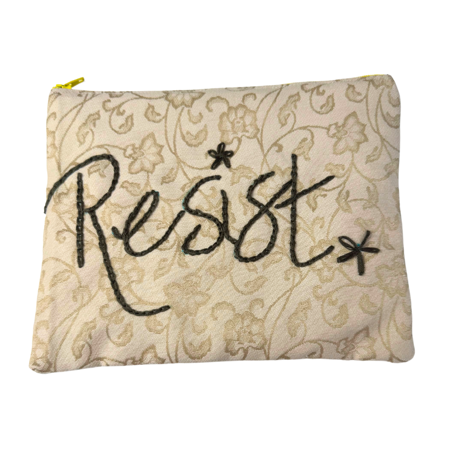 Clutch with “Resist” hand embroidery on beige floral background
