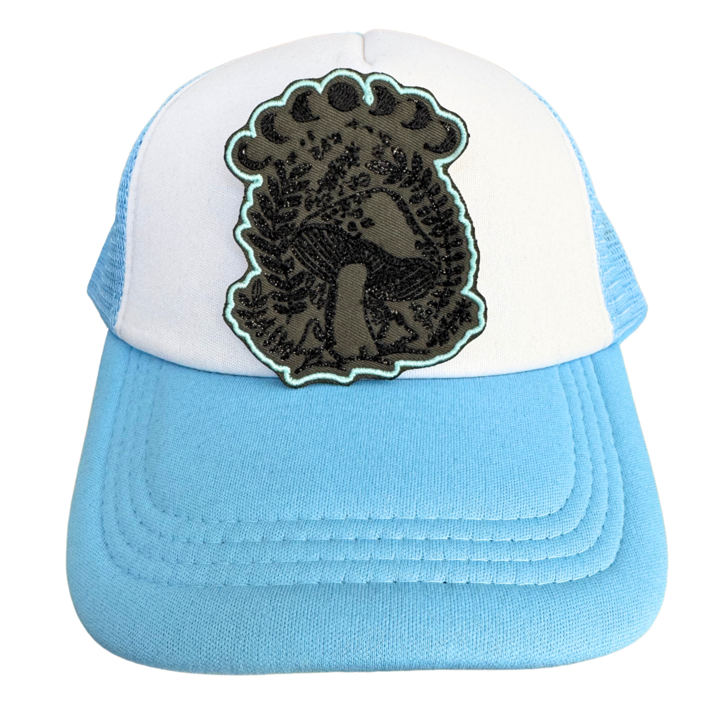 Blue and white trucker hat styled with the Mushroom Moon Phase embroidered patch, perfect for gothic and nature-inspired fashion.
