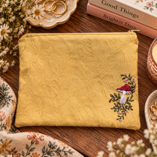 Hand-embroidered mushroom zipper clutch styled product photo