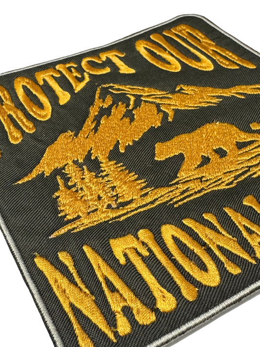 Close-up of yellow stitching on forest green fabric patch
