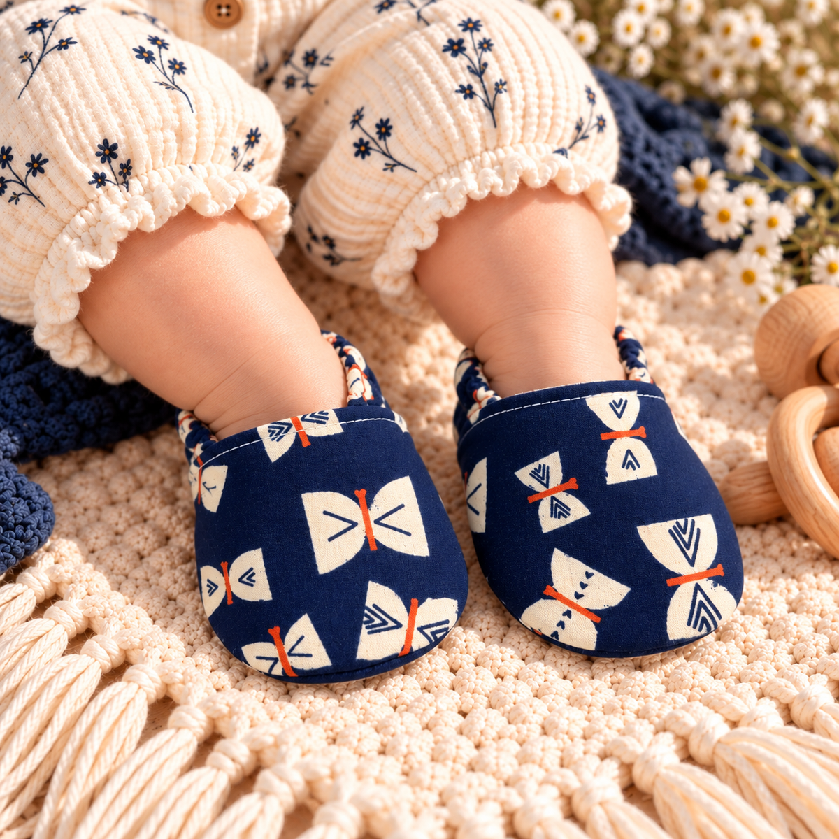 Navy butterfly soft sole baby moccasins worn by baby