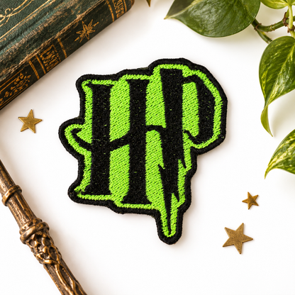 Neon green and black embroidered HP monogram patch on white with vintage book and gold star accents
