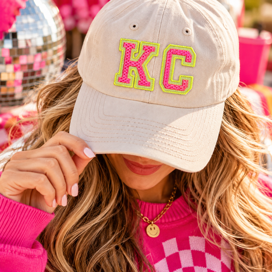 Neon KC Varsity iron-on patch styled on cream hat