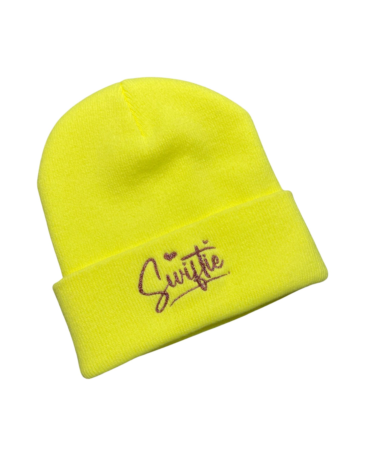 neon yellow knit beanie embroidered in pink holographic glitter to say Swiftie in cursive with hearts for the dots on the I's
