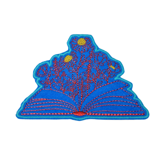 Front view of open book floral embroidered iron-on patch with wildflowers
