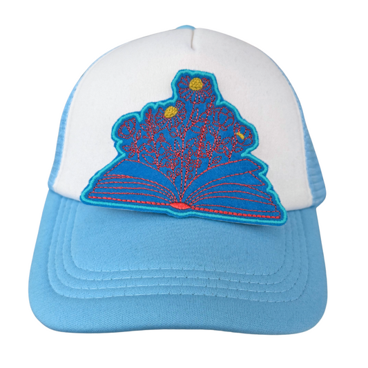 Open book floral patch on blue and white trucker hat
