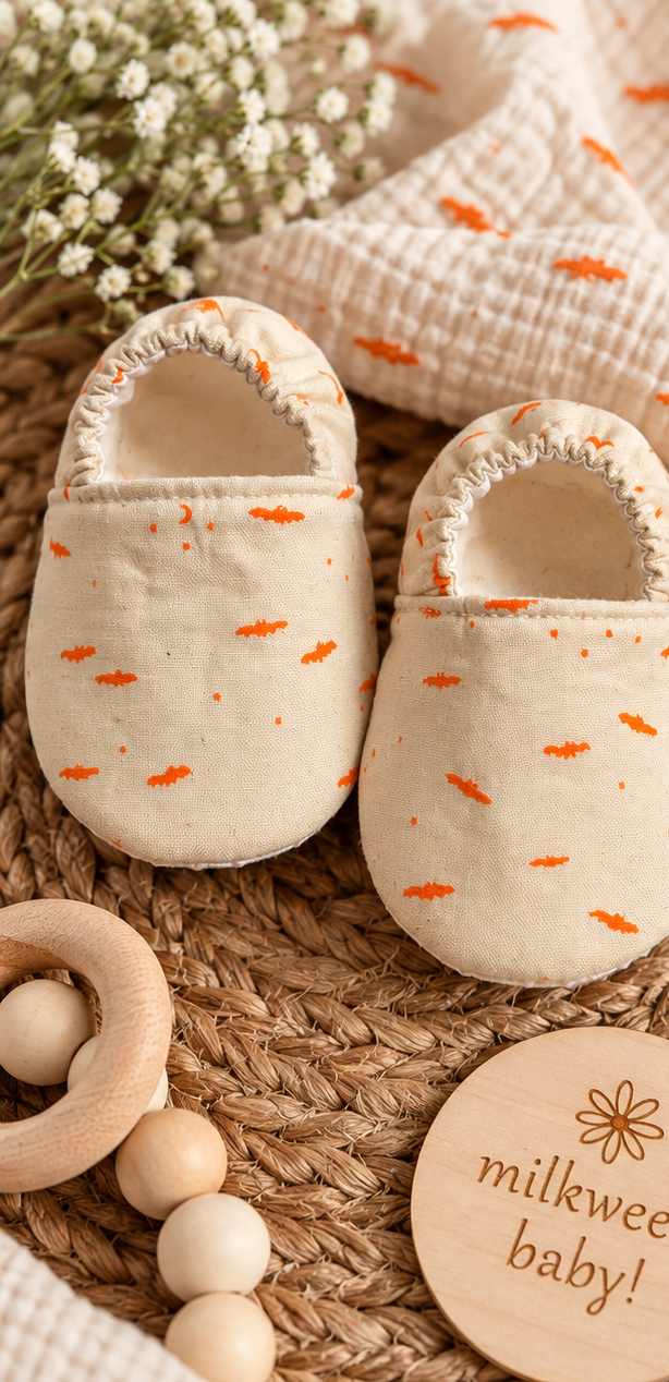 Handmade cream cotton baby shoes with tiny orange bat print, size 6-9 months