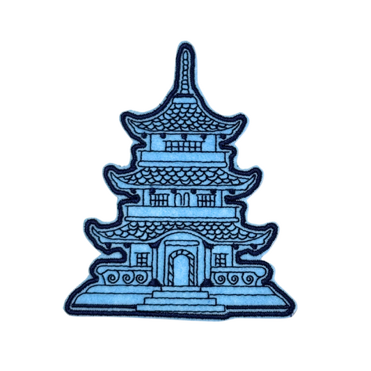 Close-up of a blue pagoda embroidered patch with intricate architectural details.
