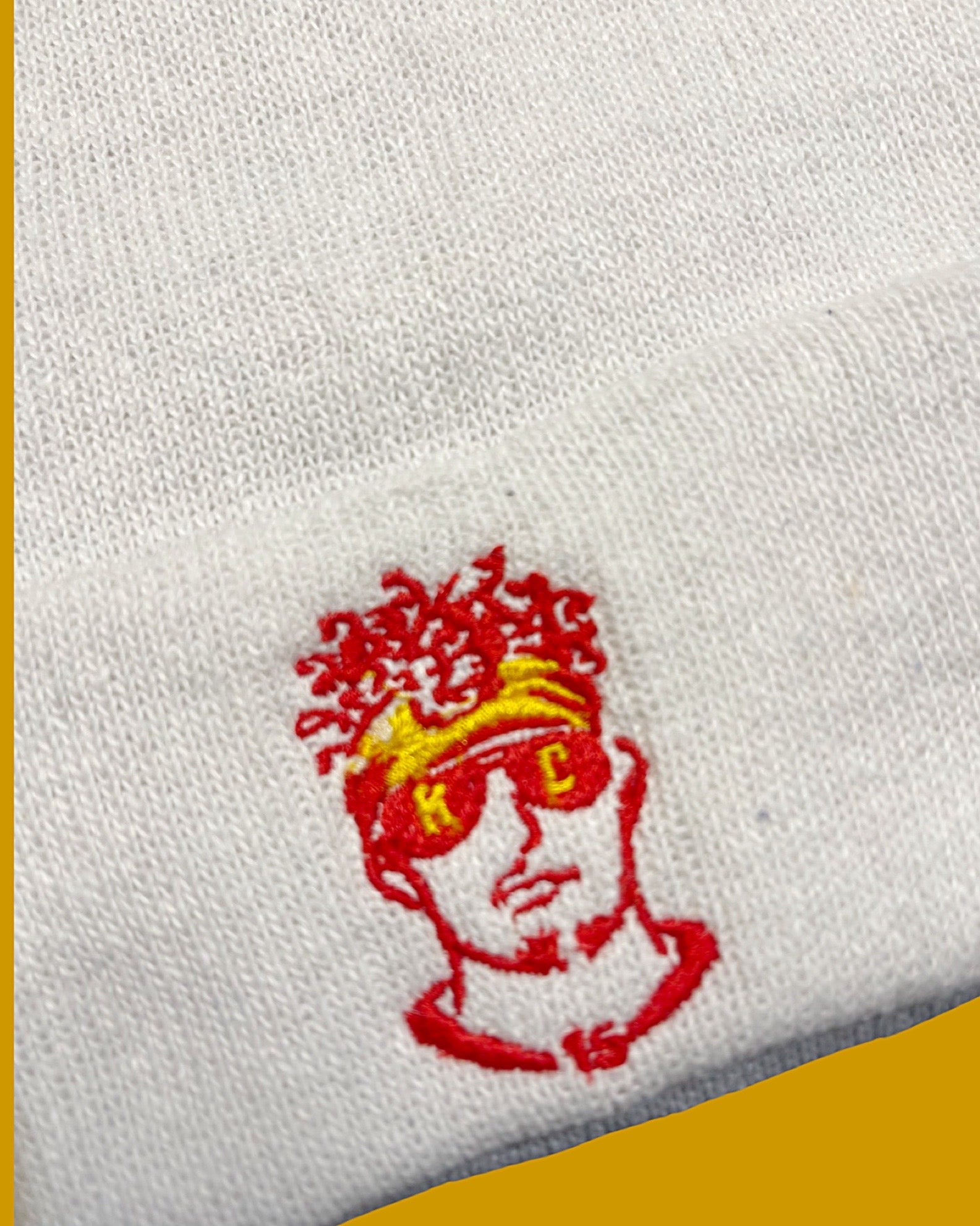 closeup of embroidery of fan art Patrick mahomet on white knit beanie