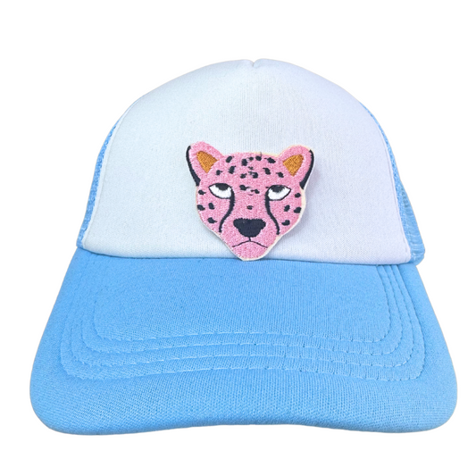White and blue trucker hat featuring a pink cheetah embroidered patch on the front.
