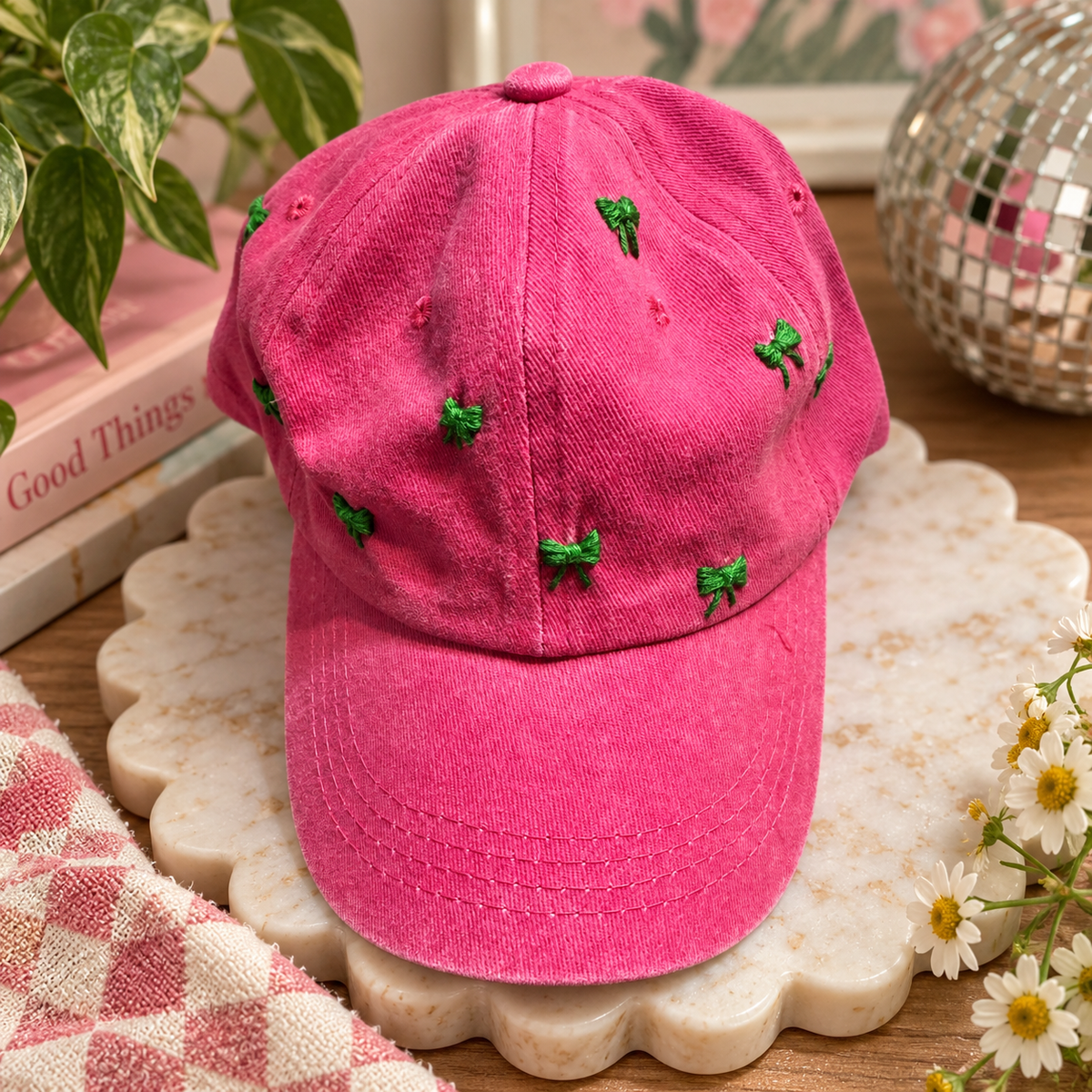 Hand-embroidered pink hat with green bows styled product photo