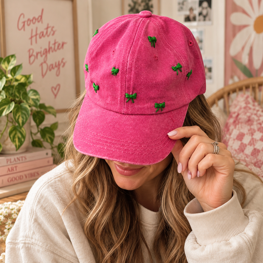 Woman wearing hand-embroidered pink hat with green bows