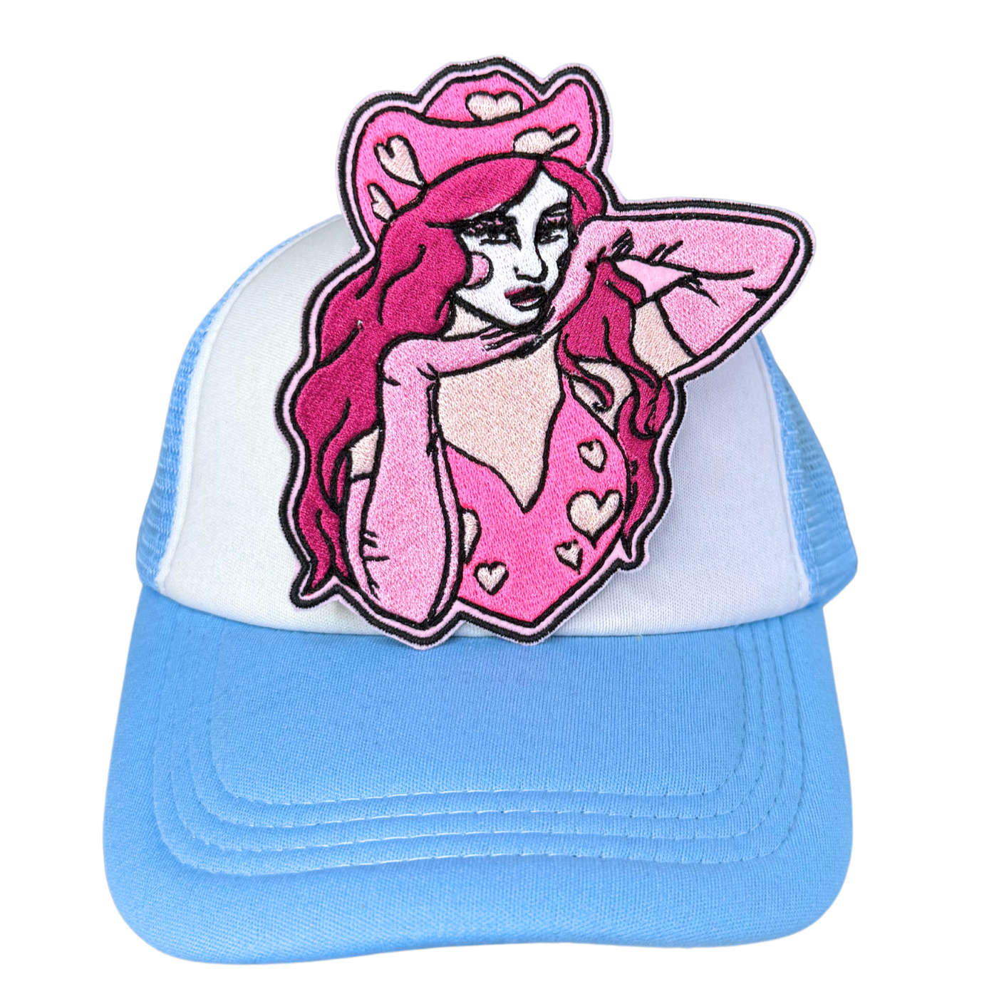 Pink cowgirl embroidered patch attached to a light blue and white trucker hat.
