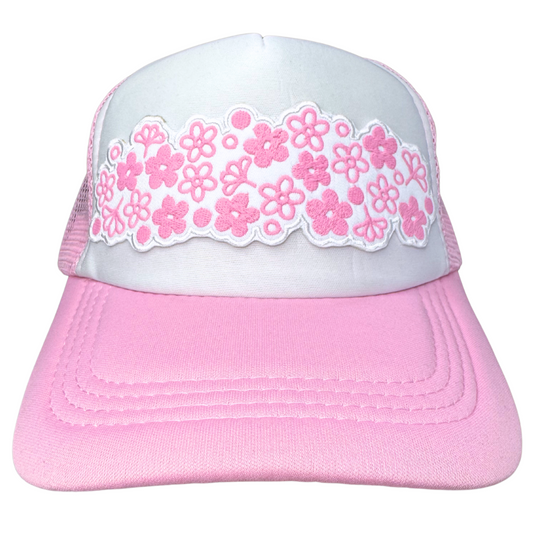 Front view of white and pink trucker hat with embroidered pink floral patch inspired by vintage Pyrex Spring Blossom
