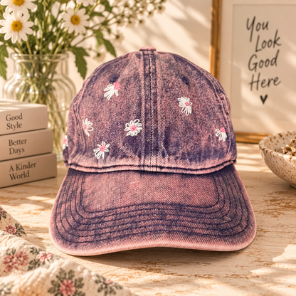 Pink stone-wash baseball cap with hand-embroidered daisies in a warm styled setting