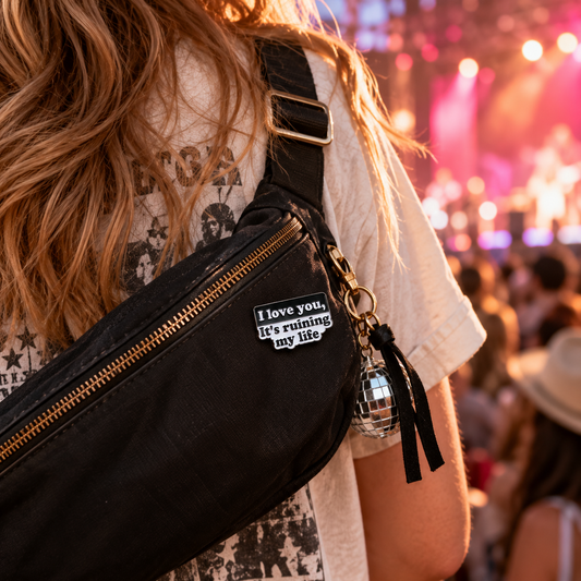 Black and white quote enamel pin on concert crossbody bag