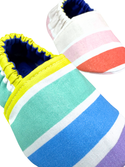 “Close-up of rainbow striped baby moccasins with yellow and white elastic and vibrant colors, 3–6 months”

