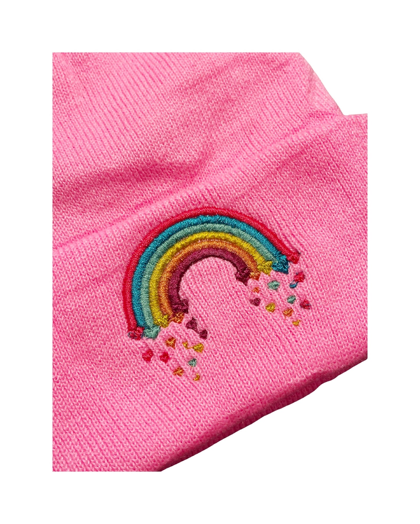 closeup of embroidery on neon pink beanie, embroidery is a brightly colored rainbow that is raining hearts