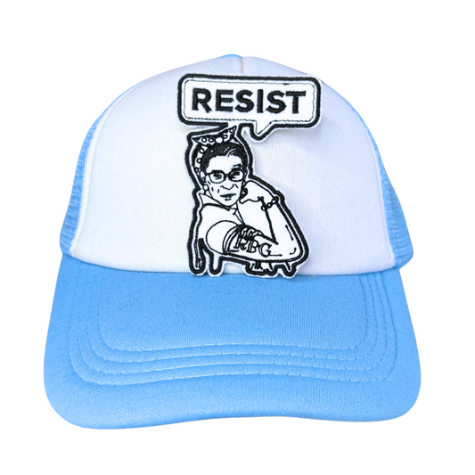 RBG "Resist" embroidered patch attached to a light blue and white trucker hat.
