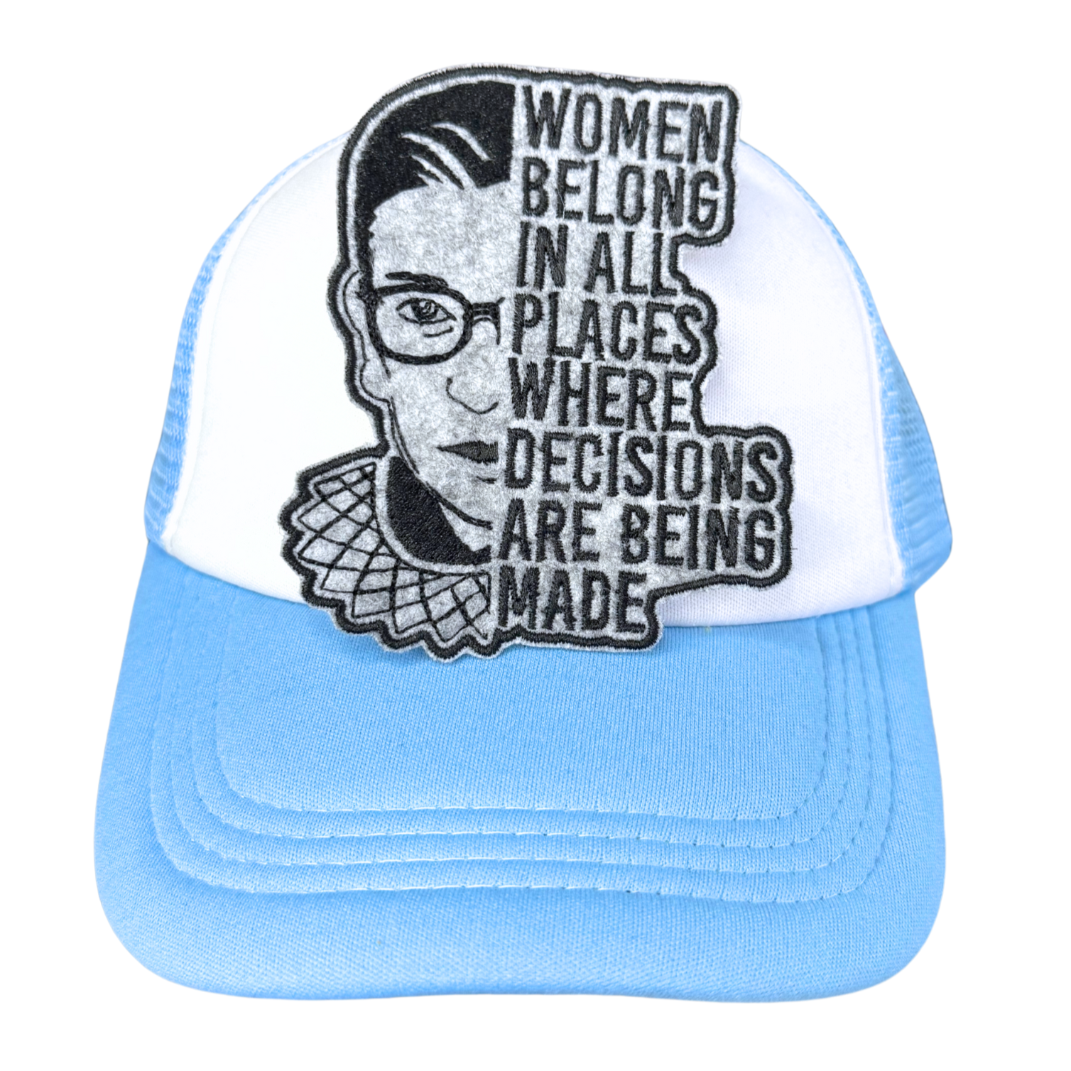"Blue and white trucker hat with an embroidered RBG patch that reads 'Women belong in all places where decisions are being made.'"
