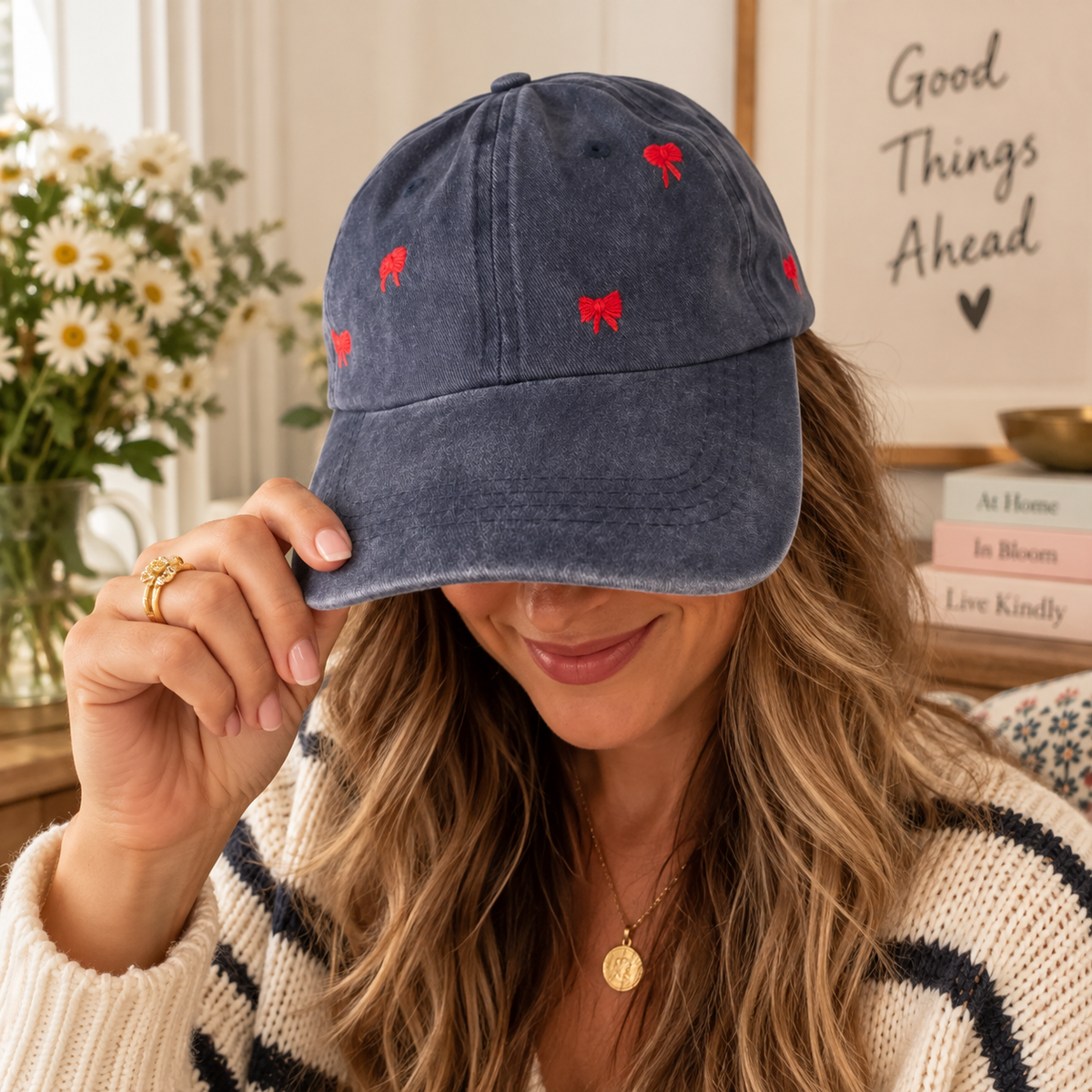Woman wearing navy baseball hat with hand-embroidered red bows