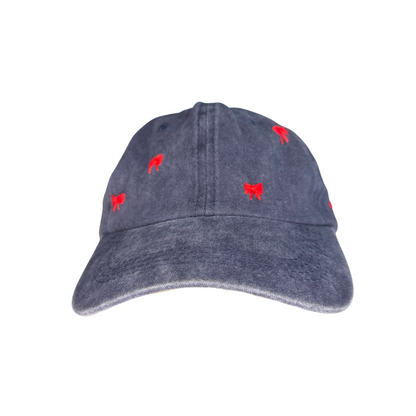 Navy blue hand-embroidered red bow baseball hat on white background