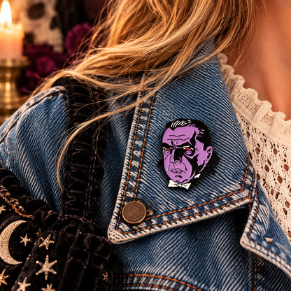 Purple retro vampire enamel pin worn on a denim jacket